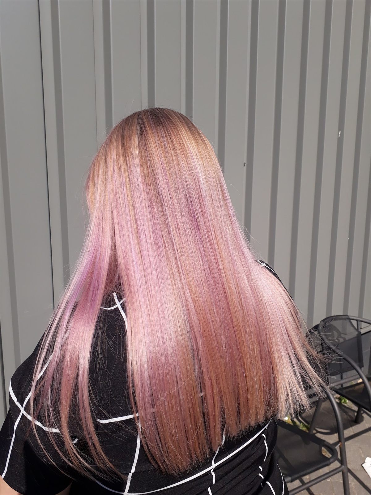 Lang, steil haar in een zachte roze tint, van achteren gezien