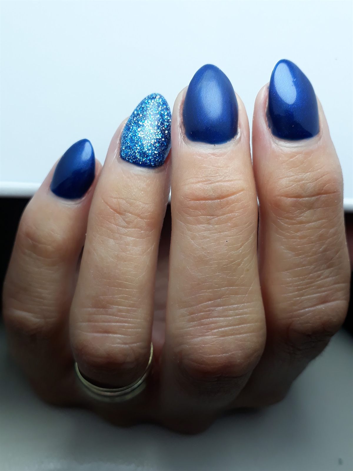 Donkerblauwe amandelvormige nagels met één glitternagel