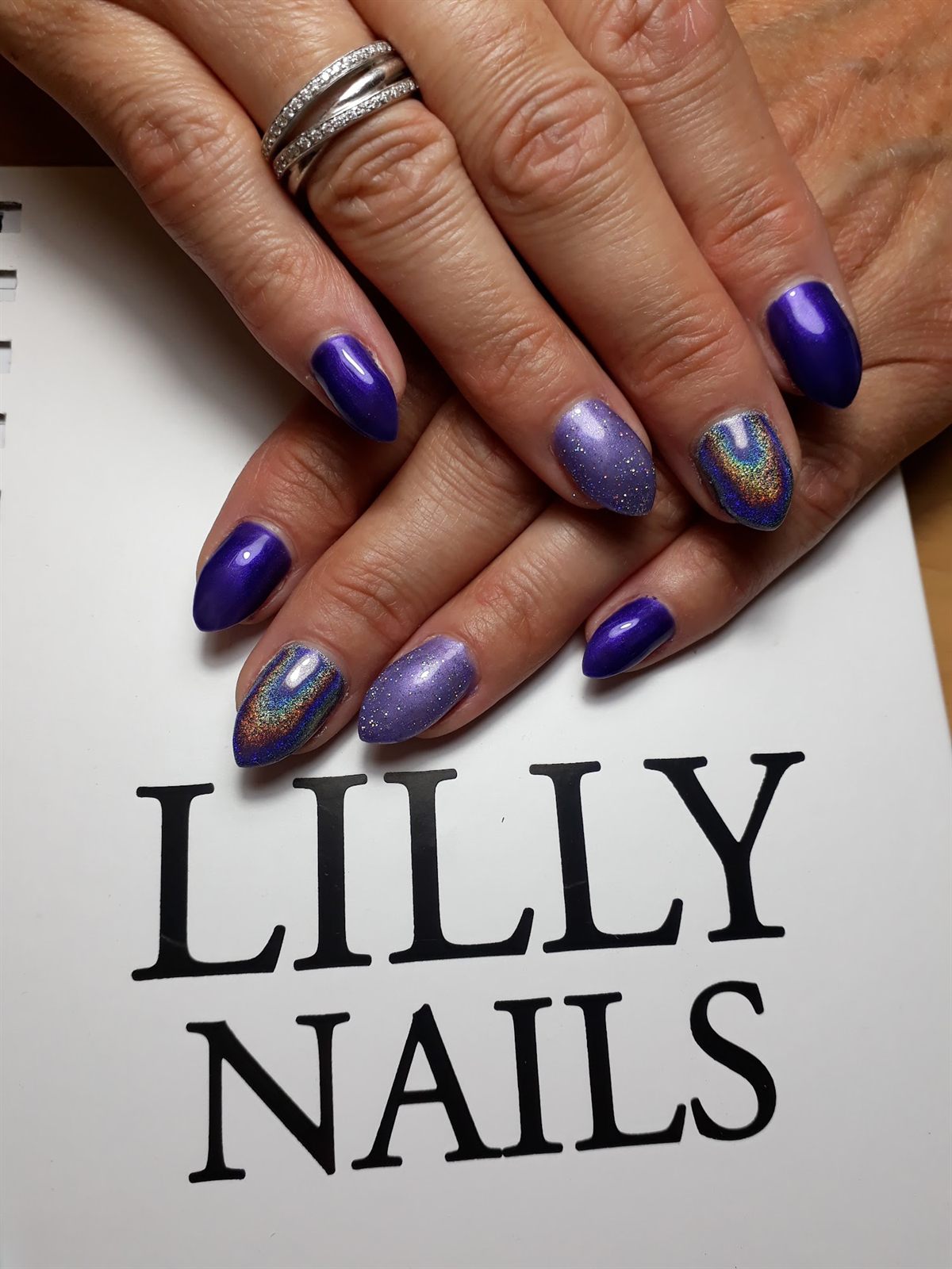 Paarse en holografische nagels boven een kaartje van Lilly Nails