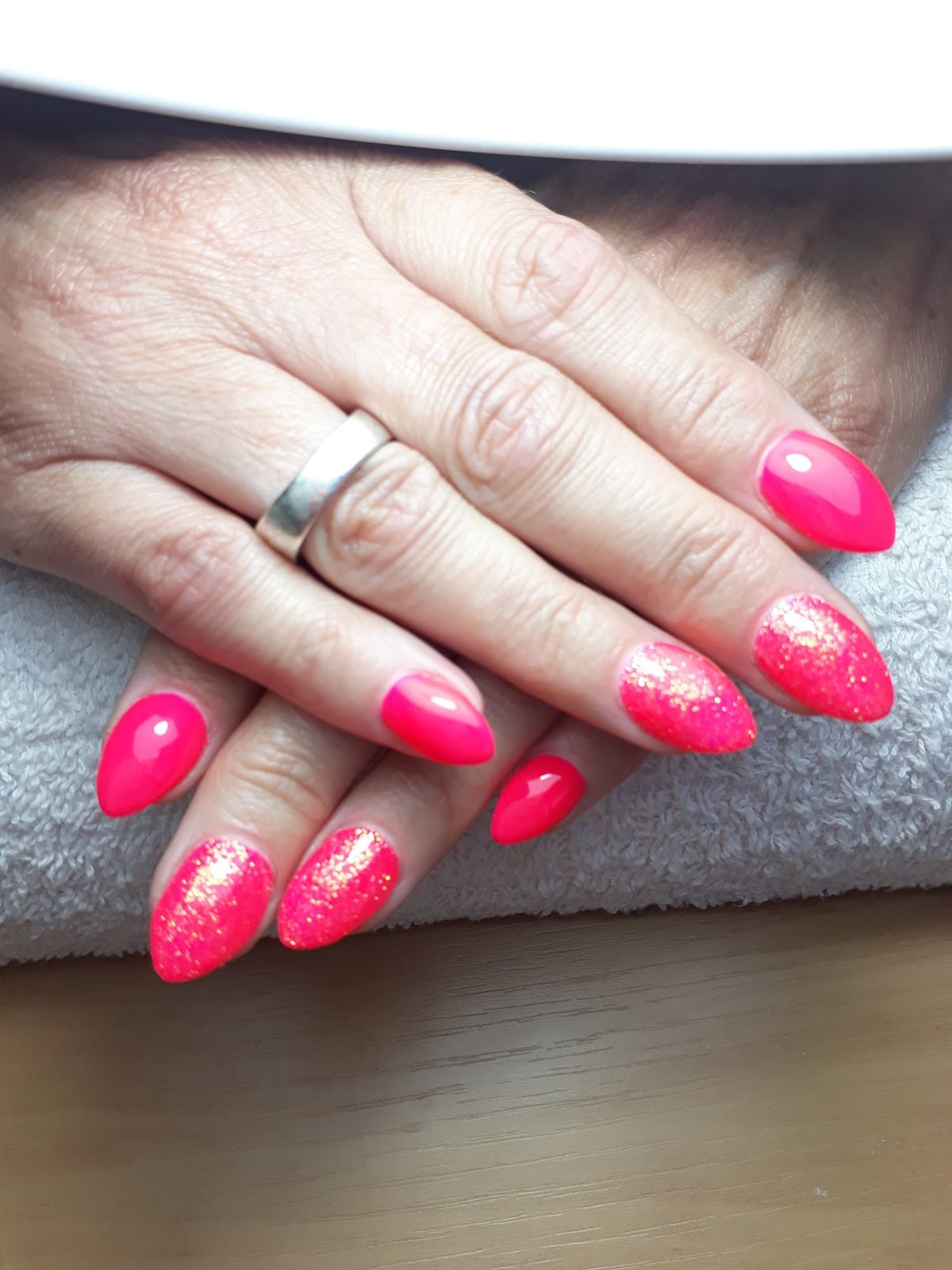 Felroze nagels met roze glitter op de ringvingers